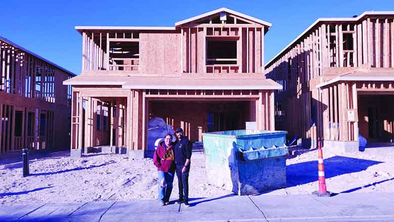 Couple Standing in front of Wooden Bungalow