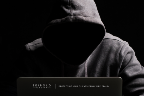Creepy hacker sitting at a computer.