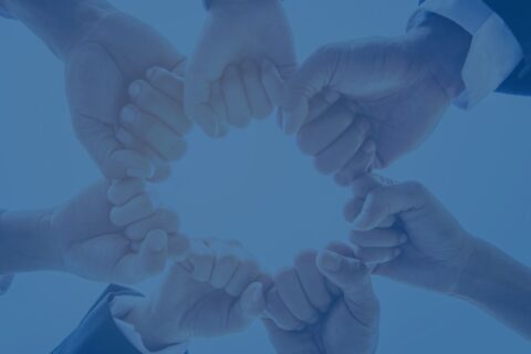 A team of commercial real estate professionals hands in a circle representing teamwork